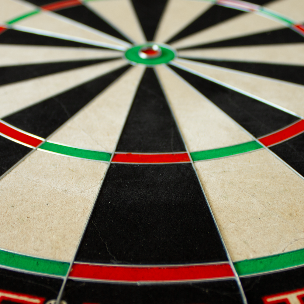 Das Bild zeigt ein Unicorn Eclipse HD Trainer Board, ein spezielles Dartboard. Es ist aus der Nähe fotografiert und zeigt die farbigen Segmente in Schwarz, Weiß, Rot und Grün.