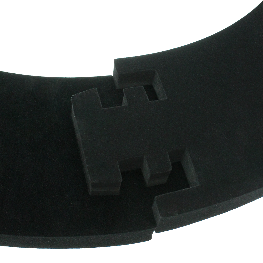 DBS3S_Bulls_Quarterback_Surround_Schwarz_4 Das Bild zeigt ein Produkt namens „Quarterback Surround“. Es handelt sich um ein gebogenes, schwarzes Schaumstoffelement mit geometrischen Aussparungen.