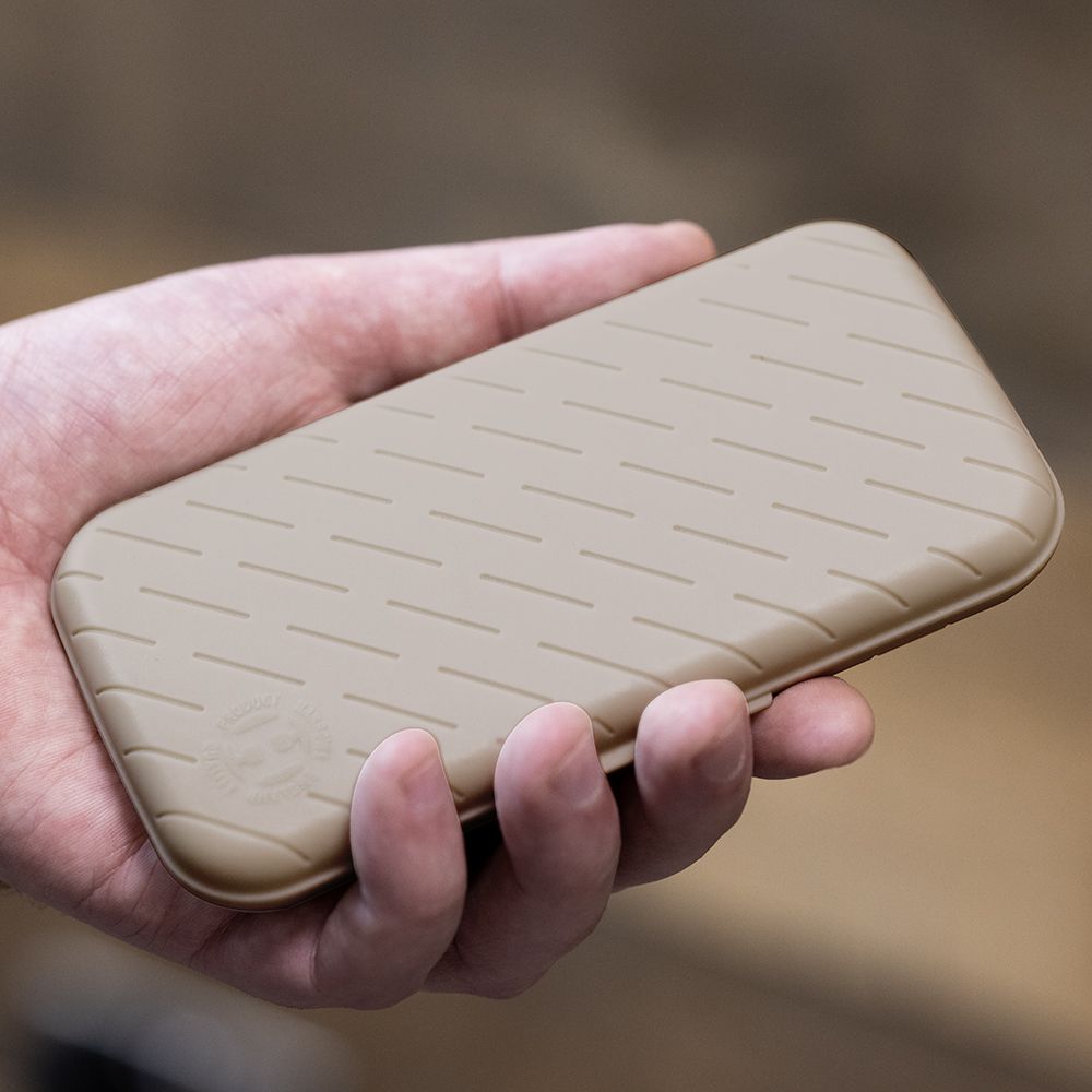 Harrows Slimcase Darttasche Eine Hand hält ein schlankes, steingraues Etui mit einem dezenten Muster. Das Etui wirkt stabil und ist wahrscheinlich für Dartzubehör gedacht.