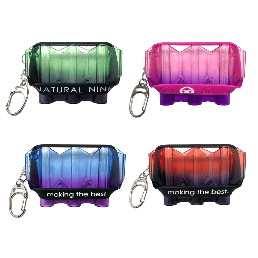 Das Bild zeigt vier verschiedenfarbige „L-Style N9 Krystal Twin Color Flightcase“-Etuis mit Schlüsselanhänger. Jedes Etui hat einen Farbverlauf und einen Schriftzug auf dem schwarzen Band.