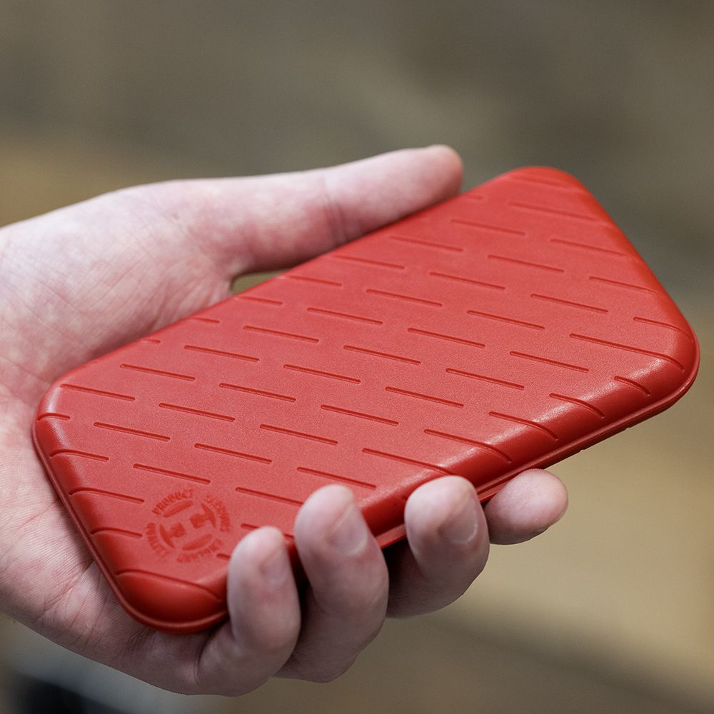 Harrows Slimcase Darttasche Eine Person hält eine rote, strukturierte Darttasche in der Hand. Die Darttasche hat eine schlanke und kompakte Form.