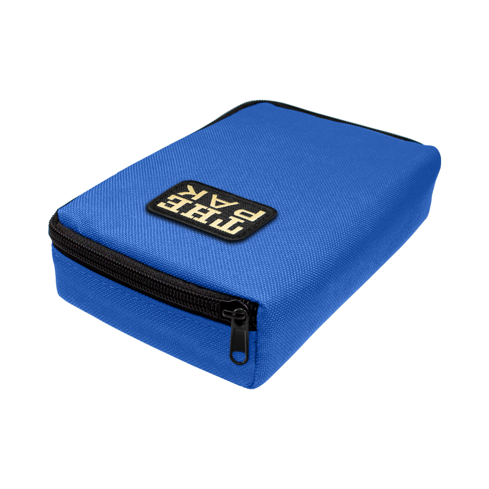 Das Bild zeigt ein blaues Etui mit einem schwarzen Reißverschluss. Auf der Oberseite befindet sich ein Patch mit der Aufschrift "THE PAK".
