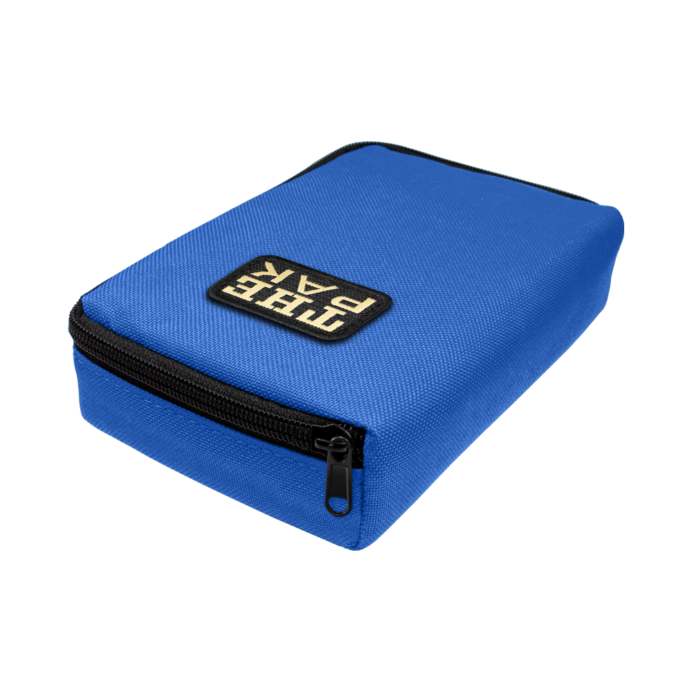 707TP_The_Pak_Dartcase_Blau_2 Das Bild zeigt ein blaues Etui mit einem schwarzen Reißverschluss. Auf der Oberseite befindet sich ein Patch mit der Aufschrift "THE PAK".