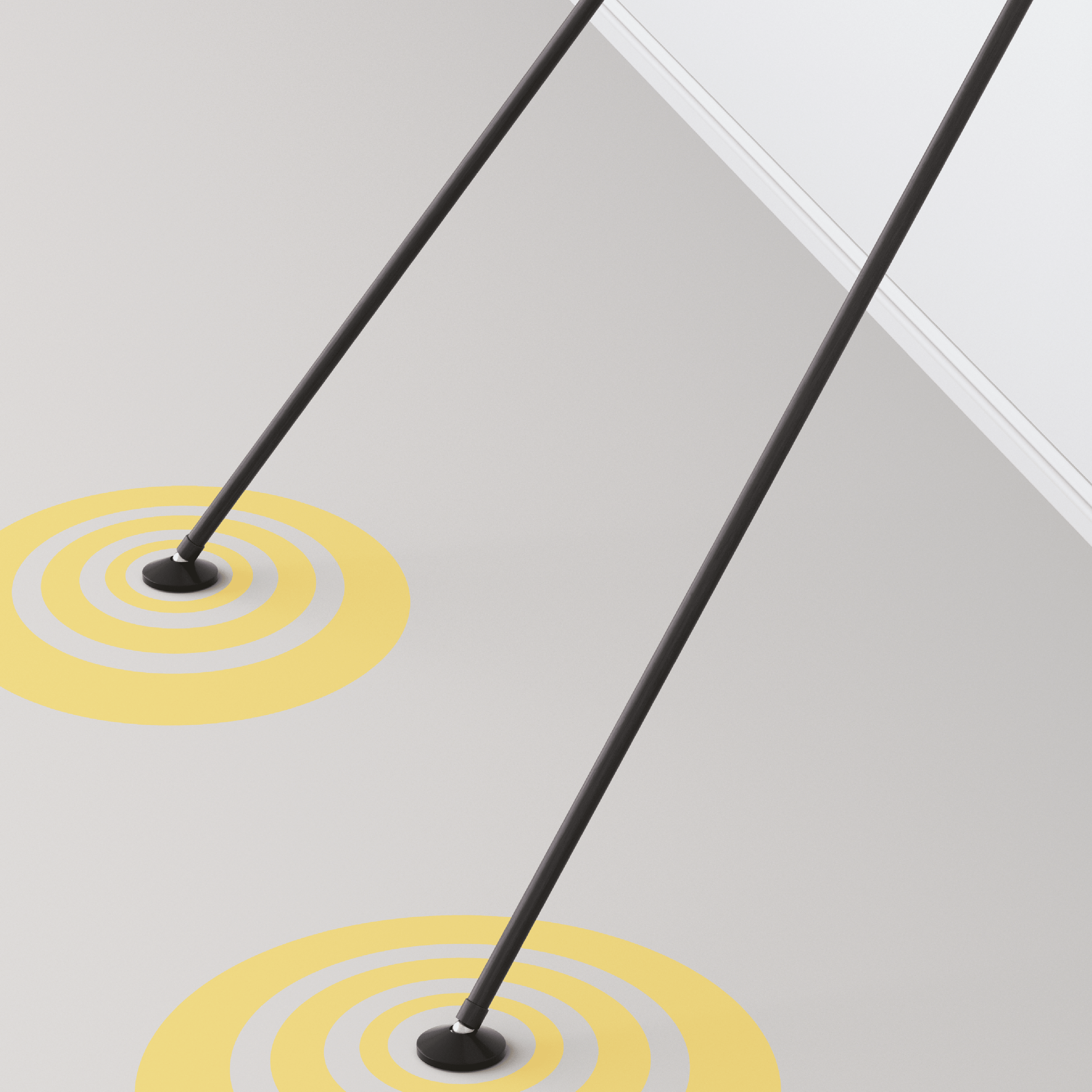 Das Bild zeigt zwei schwarze Stangen, die schräg auf dem Boden stehen und mit gelben Kreisen markiert sind. Es handelt sich um einen Teil des Winmau Vertex Dartboard Ständers.