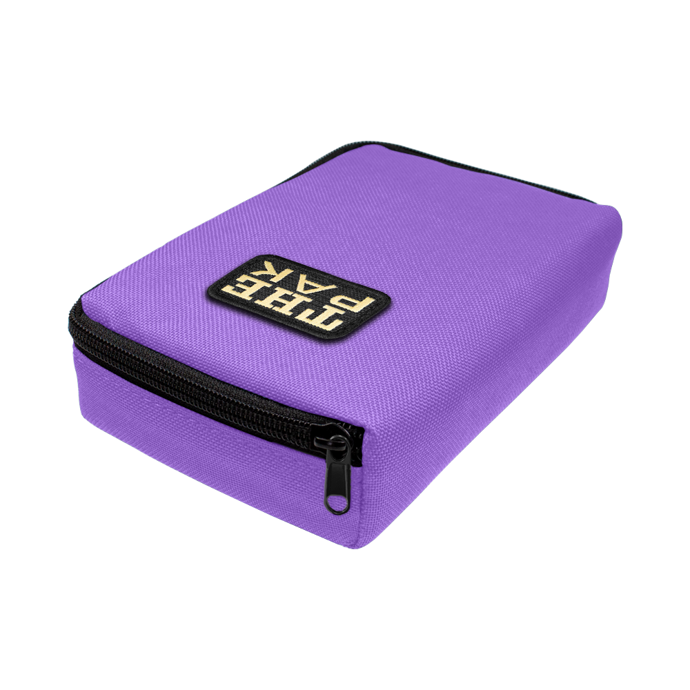 Das Bild zeigt ein lila Etui mit Reißverschluss, das "The Pak Dartcase" heißt. Auf der Oberseite befindet sich ein schwarzes Label mit weißer Schrift.